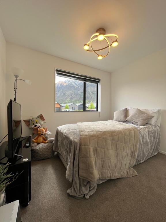 a bedroom with a bed and a television and a window at Haven in Hanley's in Frankton Wharf