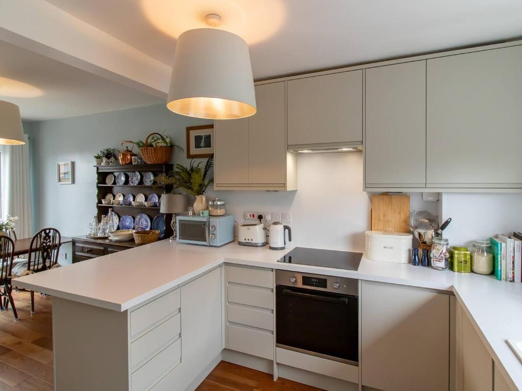 eine Küche mit weißen Schränken und einer Arbeitsplatte in der Unterkunft Pass the Keys Large homely house with parking in Ushaw Moor