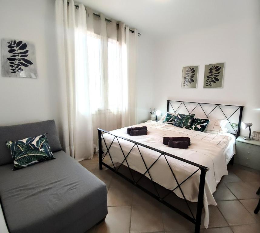 a bedroom with a large bed and a couch at Apartment M&J - Valledoria - LA Muddizza - Free WI-FI in Valledoria