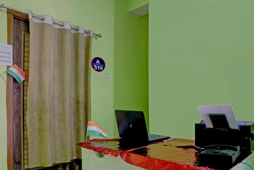 um quarto com uma mesa com dois computadores portáteis em OYO Hotel RS Guest House em Katni