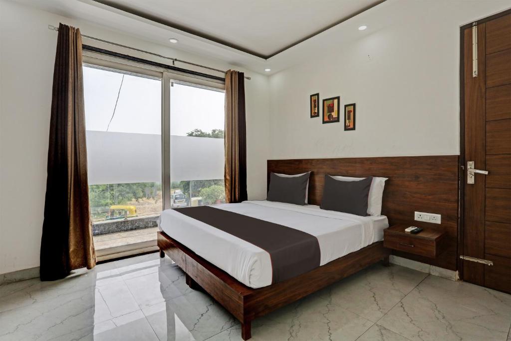 een slaapkamer met een groot bed en een groot raam bij Collection O Vikrant Residency in Gurgaon