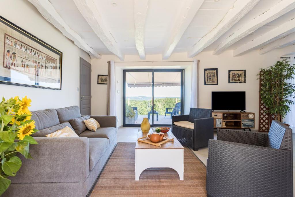 un salon avec un canapé, des chaises et une télévision dans l'établissement les coteaux de Proumeyssac, à Audrix