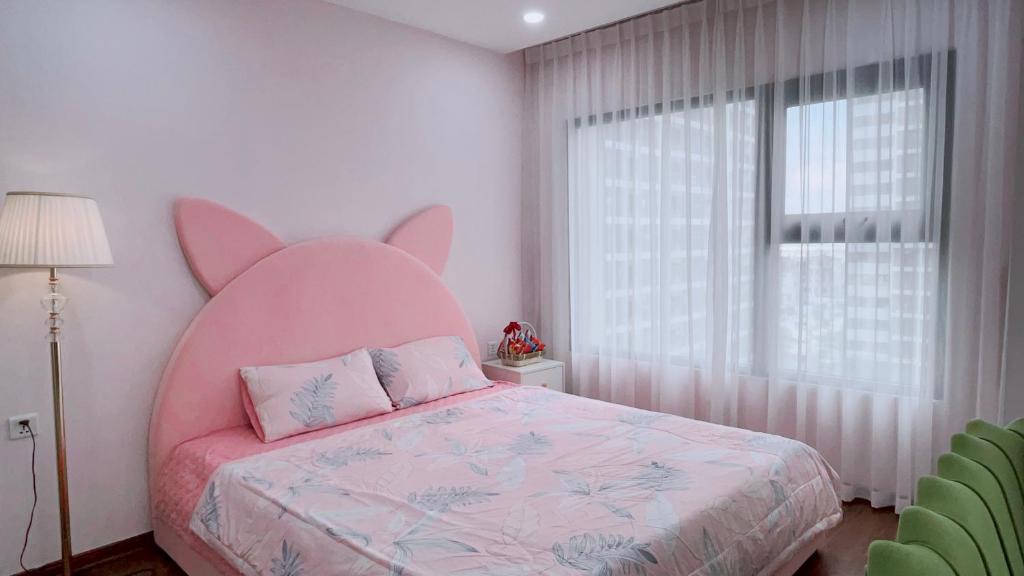 een slaapkamer met een groot bed met een groot roze hoofdeinde bij Homestay Vinhomes Ocean Park in Gia Lâm Pho