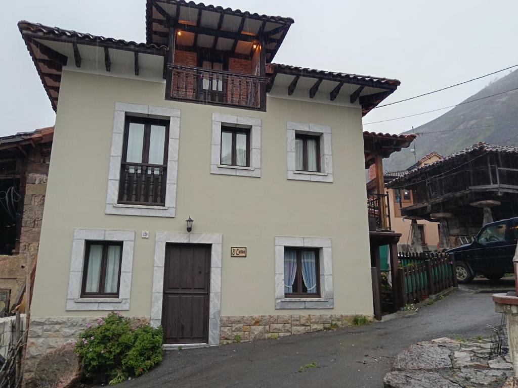uma casa branca com um telhado preto em El Cantón em Cangas de Onís