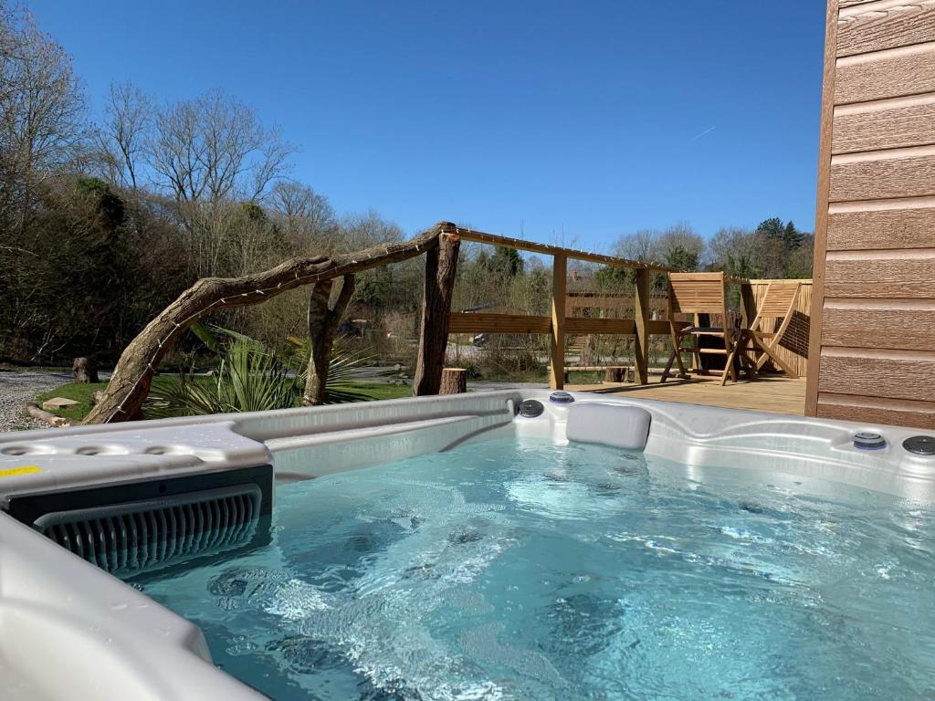 a hot tub in the middle of a yard at Herons Lake Retreat Lodges in Caerwys