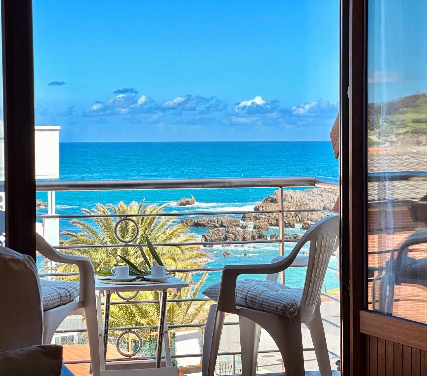 a room with a view of the ocean from a balcony at Apartamentos Pineda in Noja