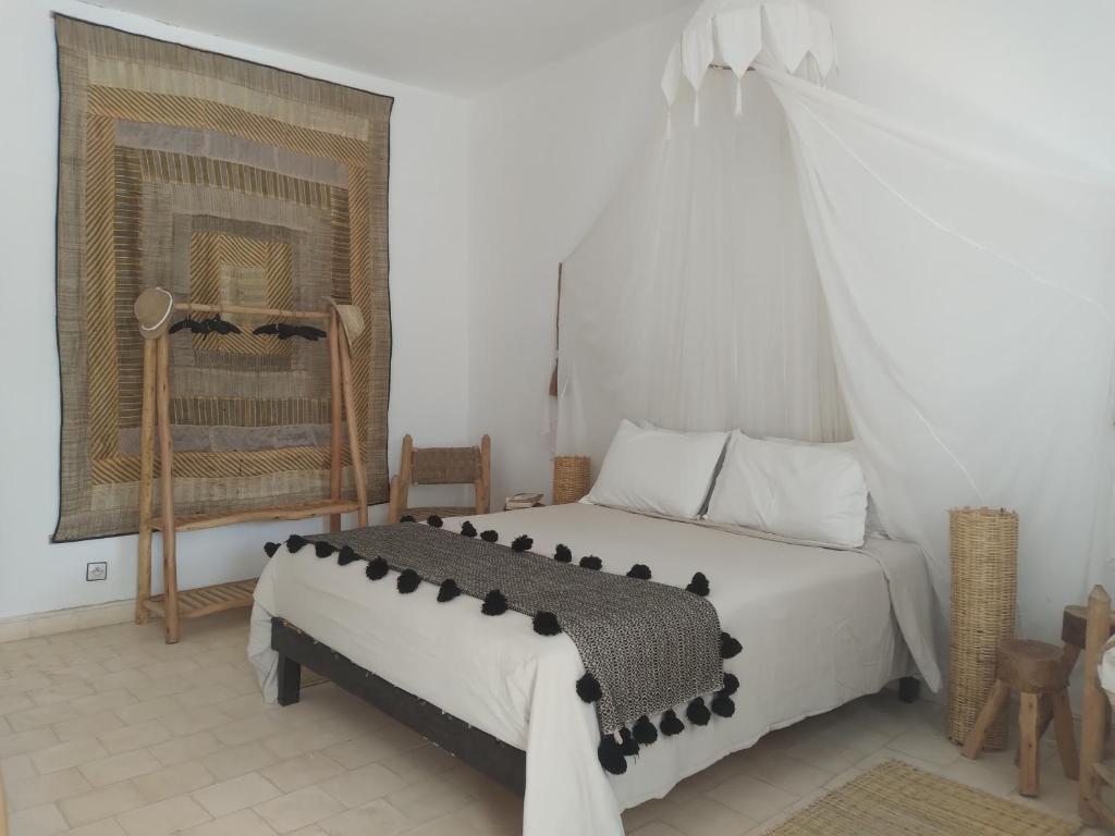 sypialnia z białym łóżkiem z baldachimem w obiekcie L' Ecrin de Mogador Essaouira w mieście Ounara