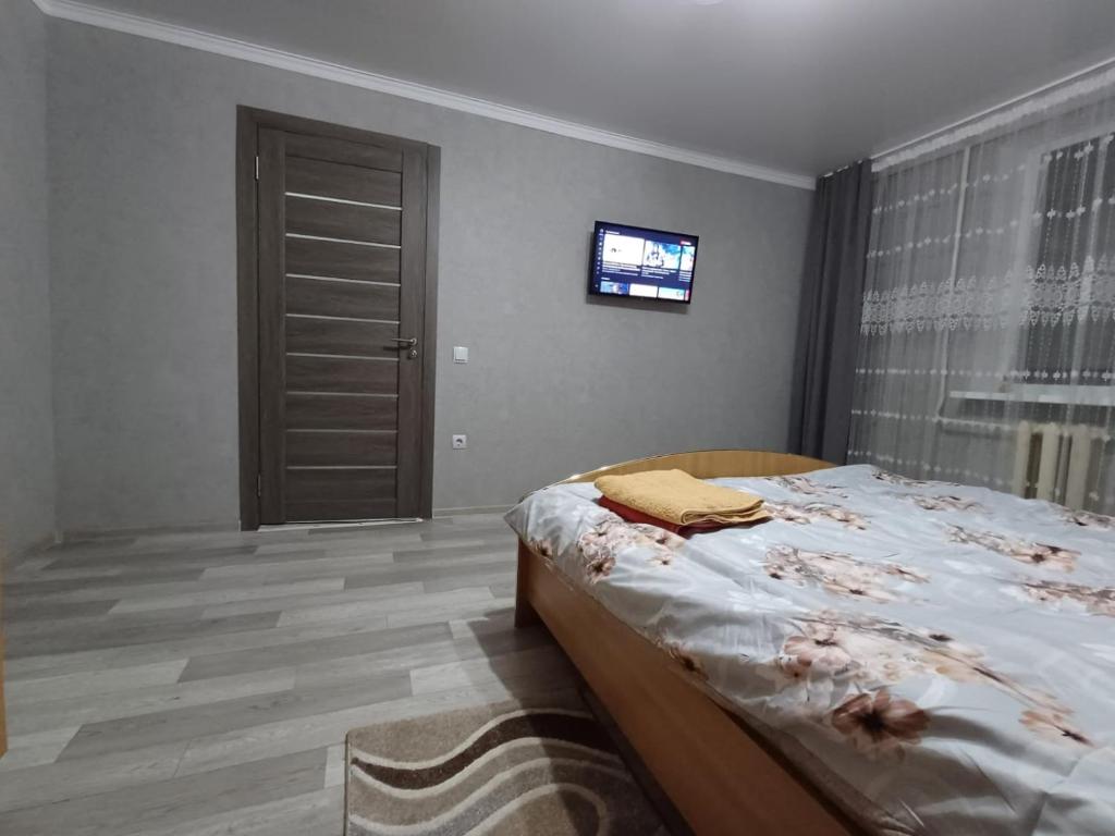 um quarto com uma cama e uma televisão na parede em Rent an apartment em Bălţi