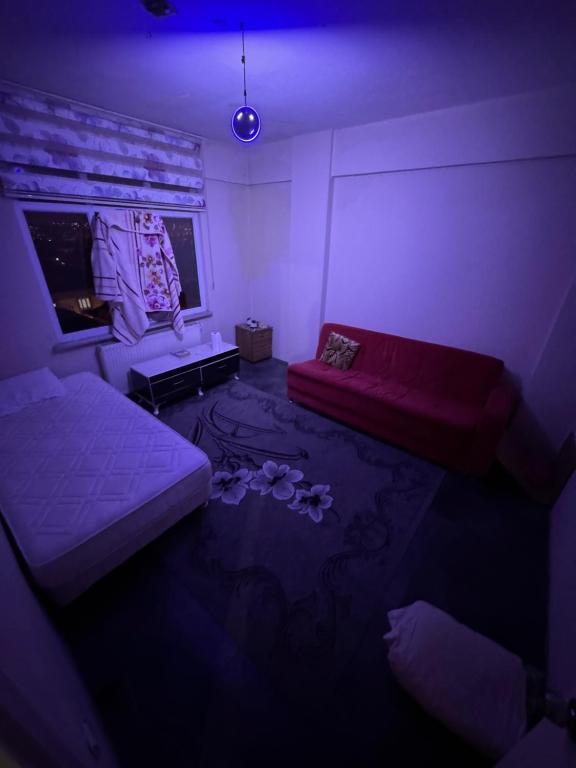 ein dunkles Zimmer mit einem Bett, einem Sofa und Blumen in der Unterkunft Beyazıt Suit in Sarıgazi