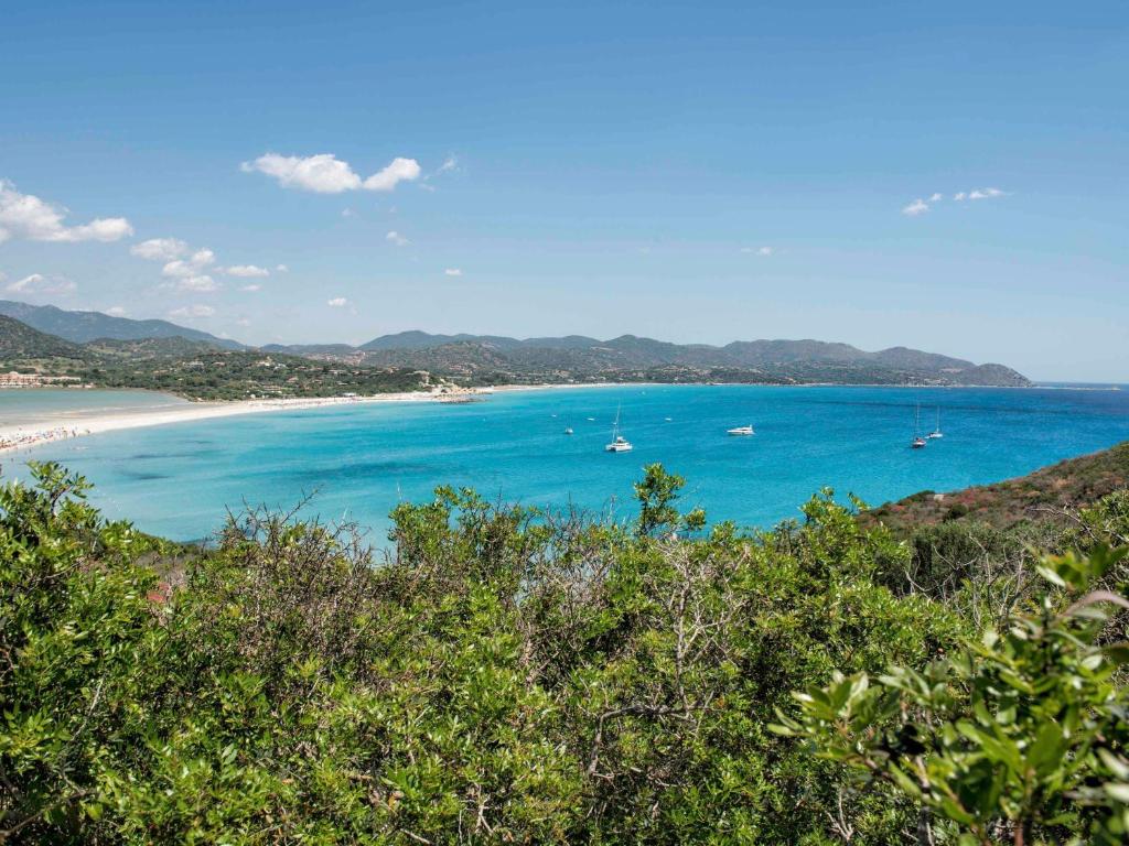a view of a beach with boats in the water at Almar Timi Ama Resort & Spa in Villasimius