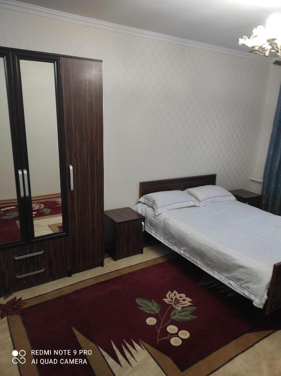 Schlafzimmer mit einem Bett und einer Glasschiebetür in der Unterkunft Your House in Karakol