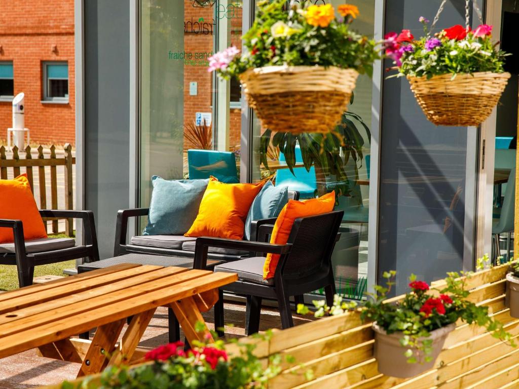 un patio con sillas, una mesa y flores en ibis budget Sheffield Arena, en Sheffield
