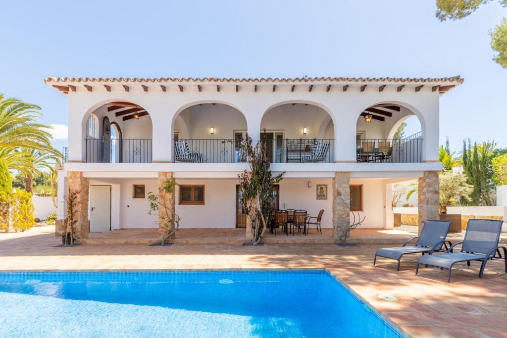 una villa con piscina y una casa en Villa Rakhi 4, en Moraira