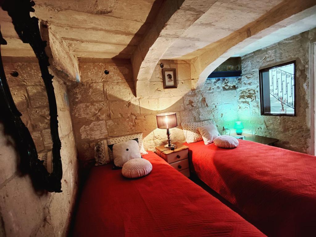 a bedroom with two beds with a teddy bear sitting on them at Traditional Maltese townhouse in Rabat in Rabat