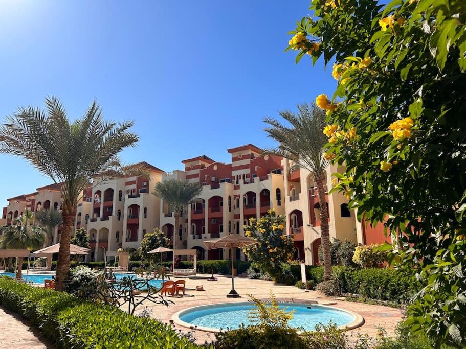 un complejo con piscina y palmeras en Studio with balcony & pool view in La Sirena Resort, en Sharm El Sheikh