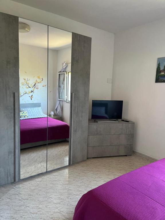- une chambre avec un miroir, un lit et une télévision dans l'établissement Monolocale Rosy 2, à Porto