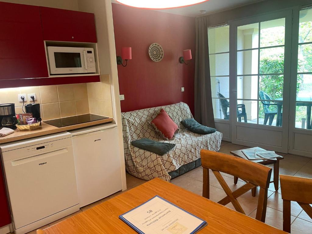 eine Küche und ein Wohnzimmer mit einem Tisch in der Unterkunft Appartement 4 pers1 chb Résidence du Lac vue sur les bois in Monflanquin