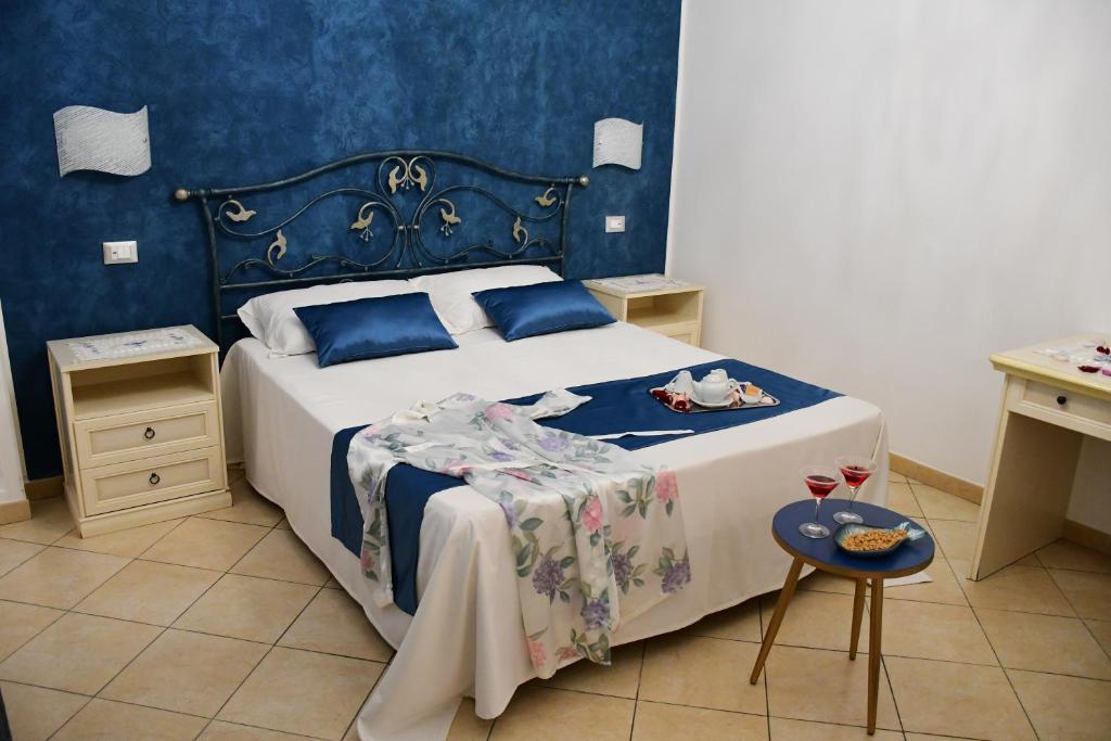 ein Schlafzimmer mit einem großen Bett mit blauen Wänden in der Unterkunft B&B Le Ortensie in San Vito lo Capo