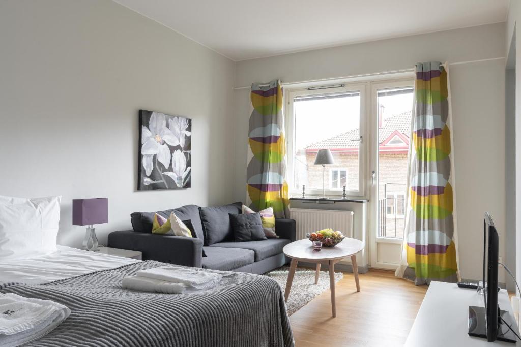 uma sala de estar com uma cama e um sofá em Live and Stay Lagerbring em Gotemburgo