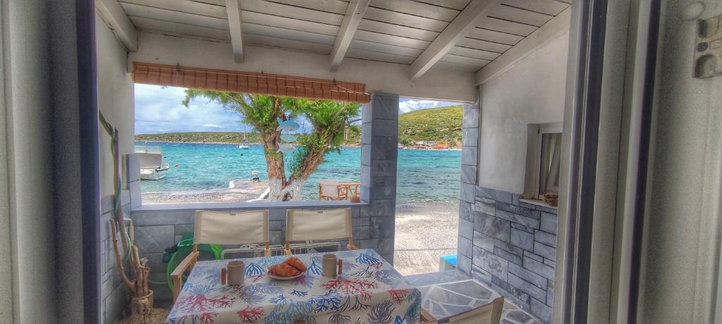 een slaapkamer met uitzicht op het strand vanuit een raam bij Merabello Beach House in Samos