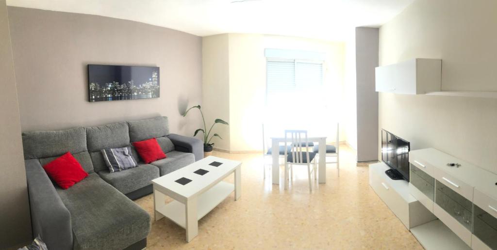 ein Wohnzimmer mit einem grauen Sofa und einem Tisch in der Unterkunft Alojamiento Mirasierra 2 in Torre del Campo