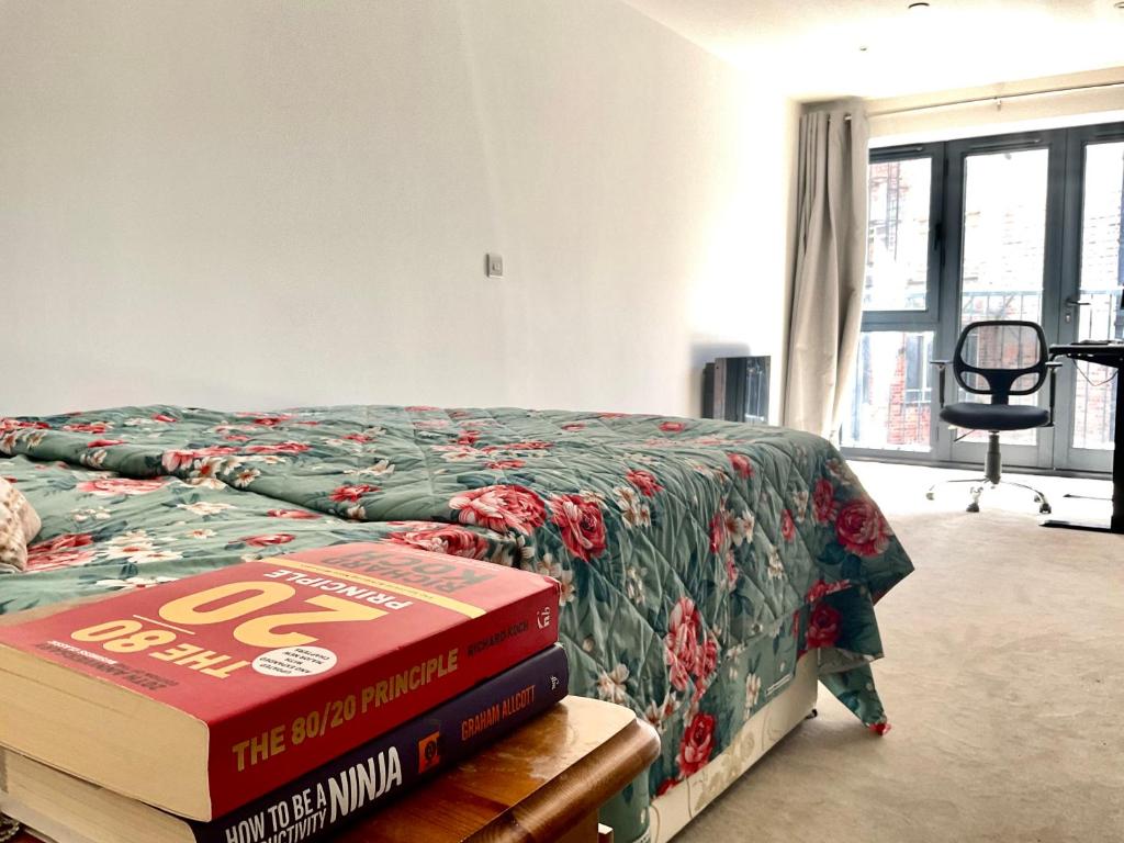 uma pilha de livros sentados numa cama num quarto em Spacious Relaxing Double Bedroom near Heart of City em Birmingham