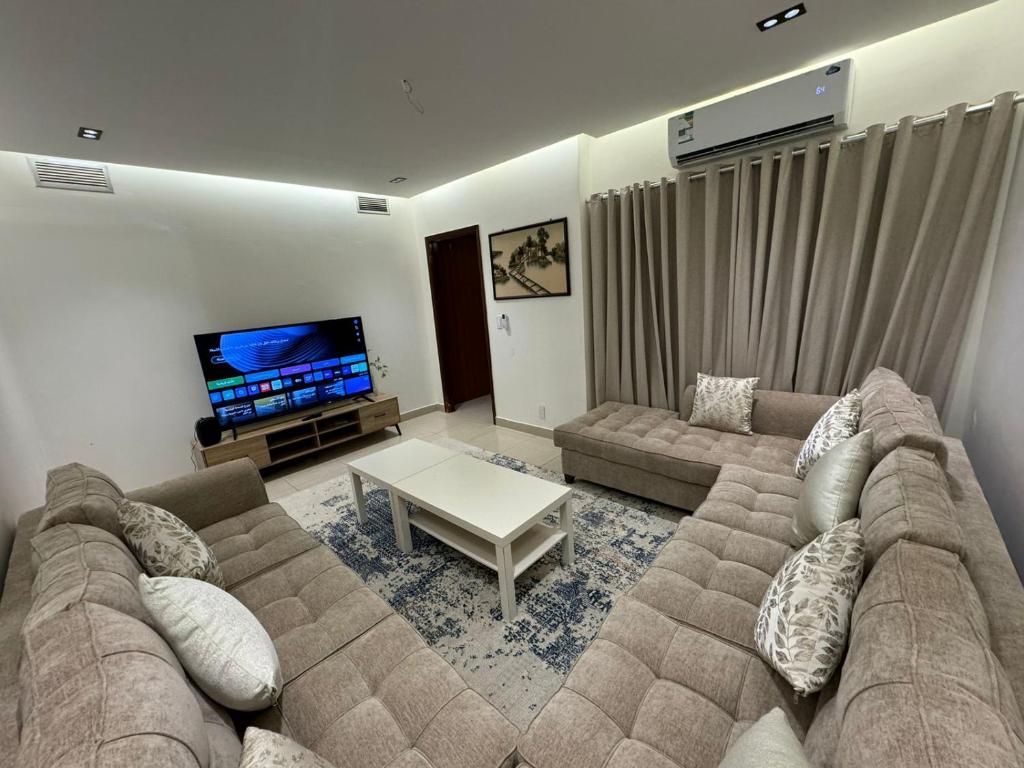 un soggiorno con divano e TV di Elegant Studio a Al Fanātīr