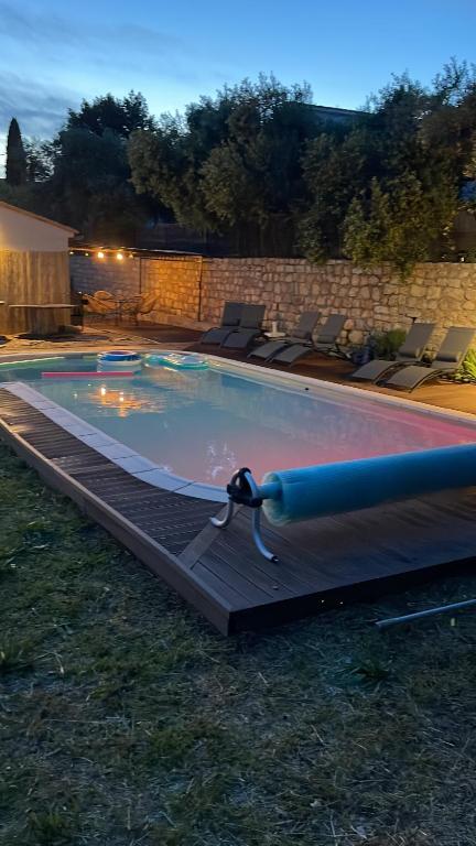 a swimming pool at night with chairs around it at Villa provençale - piscine-calme in Draguignan
