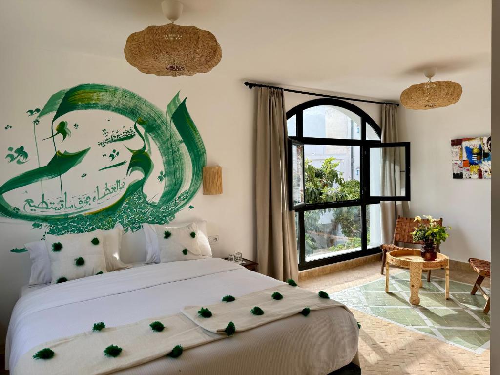 - une chambre avec un lit orné d'une peinture murale dans l'établissement RIAD OASIS D'ASILAH, à Assilah