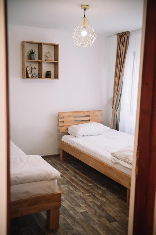 a bedroom with two beds and a chandelier at Casa Vatra Sinteului - Cu sala de evenimente de capacitate mare - Se inchiriaza integral in Socet