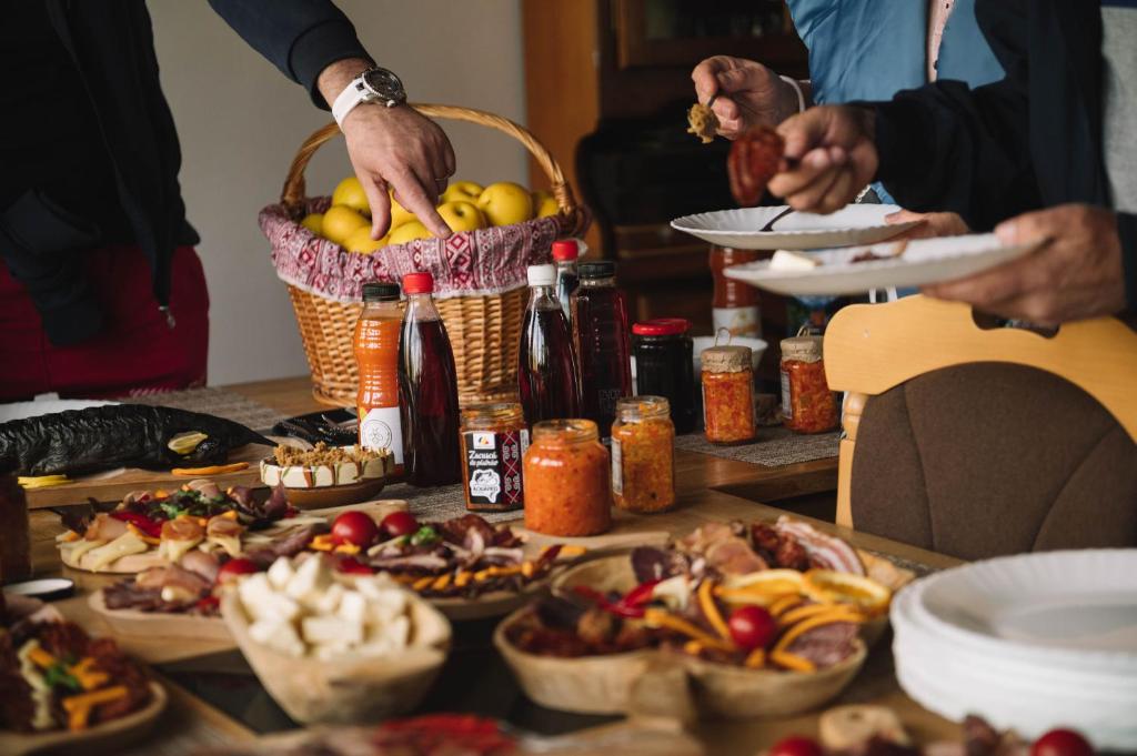 a group of people standing around a table with food at Casa Vatra Sinteului - Cu sala de evenimente de capacitate mare - Se inchiriaza integral in Socet