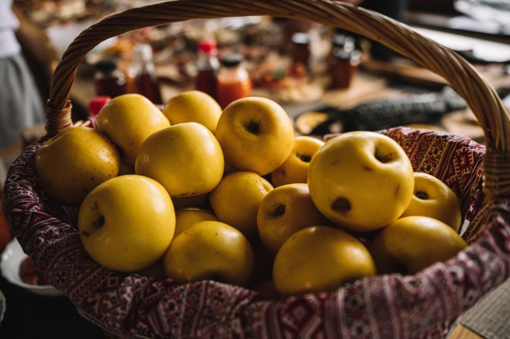 a basket filled with yellow apples on a table at Casa Vatra Sinteului - Cu sala de evenimente de capacitate mare - Se inchiriaza integral in Socet