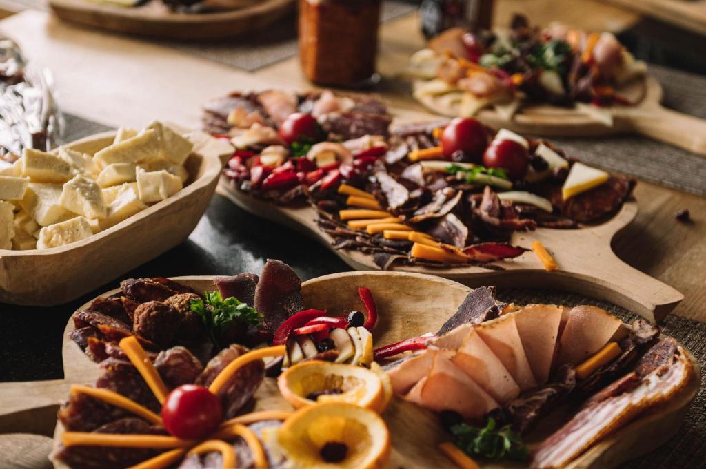 a table topped with different types of food on plates at Casa Vatra Sinteului - Cu sala de evenimente de capacitate mare - Se inchiriaza integral in Socet