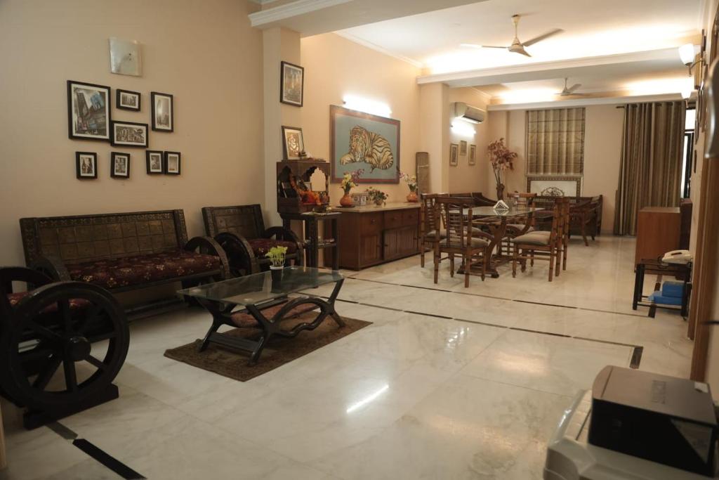 uma sala de estar com um sofá e uma sala de jantar em SUNSHINE RESIDENCY,LAJPAT NAGAR em Nova Deli