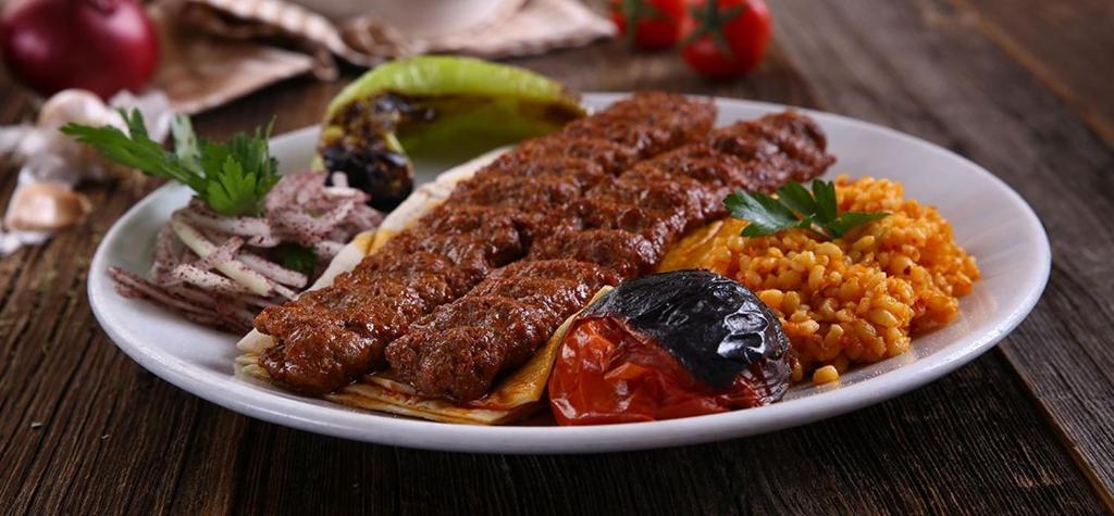 a plate of food with meat and rice on a table at The Queen Airport Hotel with free shuttle in Arnavutköy