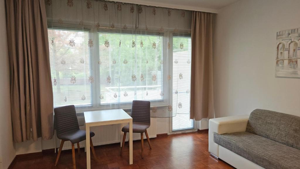 uma sala de estar com uma mesa e cadeiras e um sofá em City Apartment für Gäste in Hannover 1-2 Personen em Hanôver