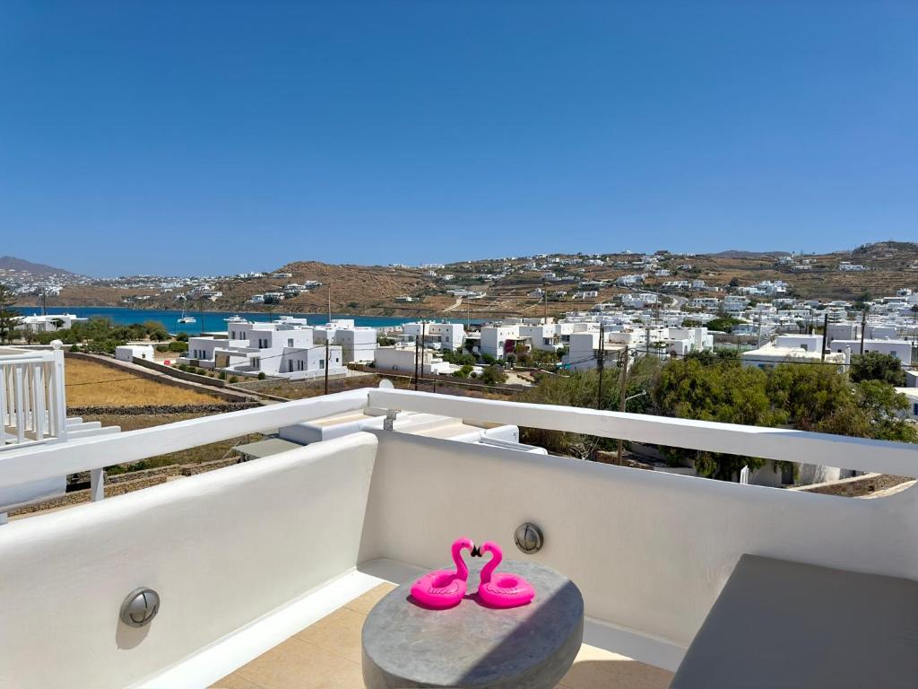 un par de zapatillas rosas sentadas en un balcón en Grace Villa Mykonos, en Mykonos ciudad
