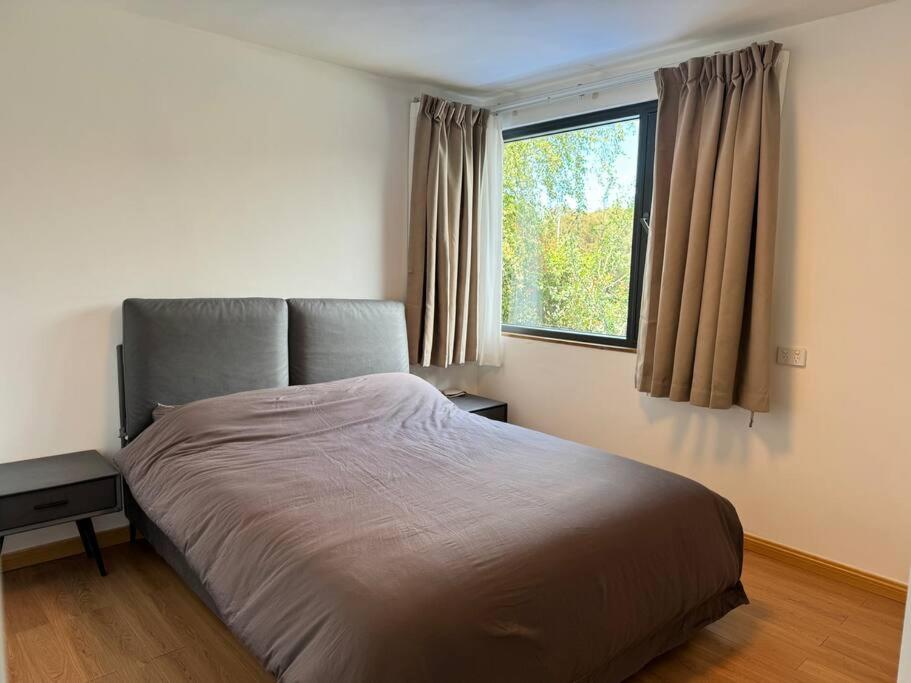 a bedroom with a large bed with a window at 1BR Apartment - Walk to City (1 Queen Bed) in Hobart