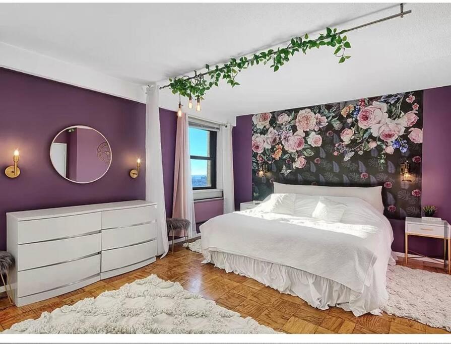 a bedroom with a large bed with a floral wall at Manhattan skyline under your feet in North Bergen