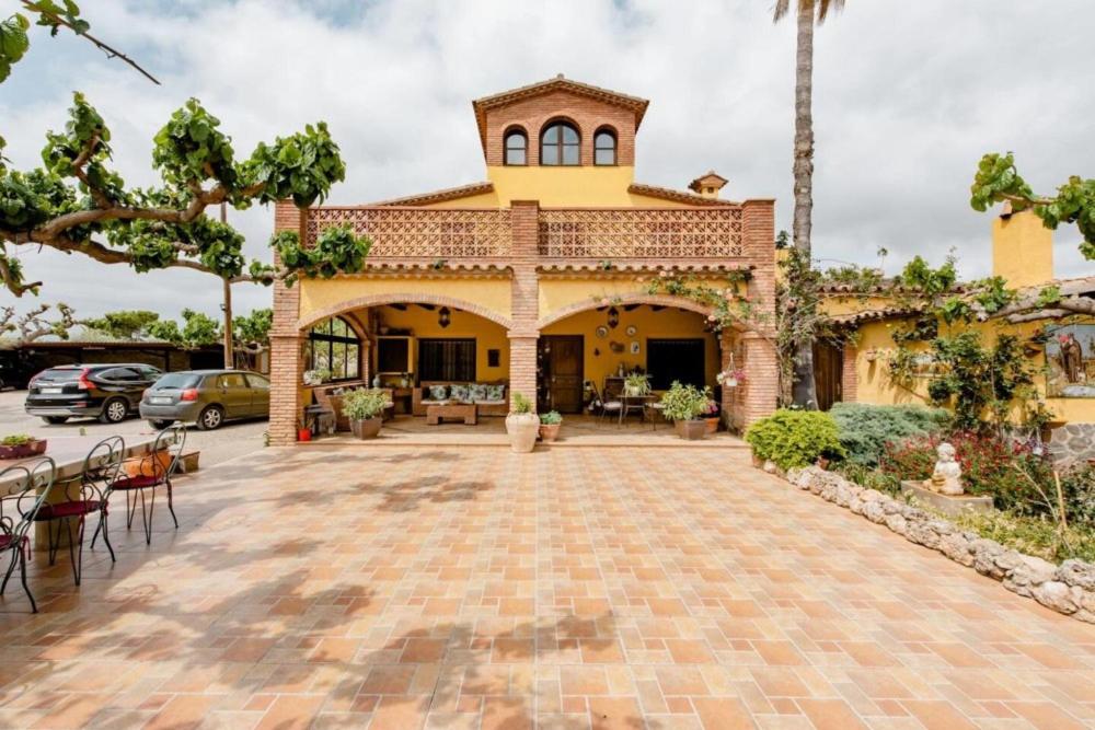 a house with a brick patio in front of it at Masia Castellvi in Vinyols i els Arcs