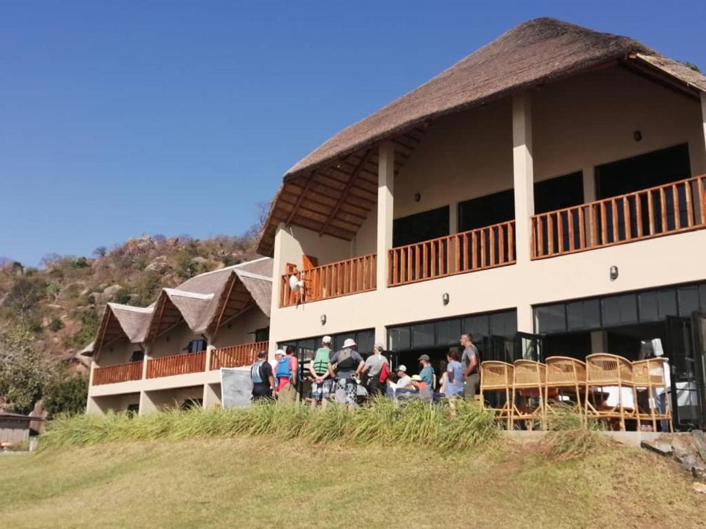 un grupo de personas parados fuera de un edificio en Joma Adventure Lodge, en Senga