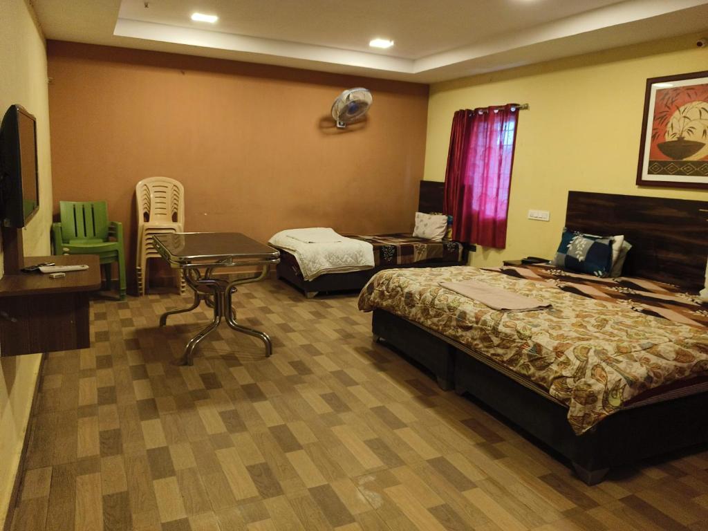 una camera d'albergo con 2 letti e una scrivania di Sri Krishna Residency a Visakhapatnam