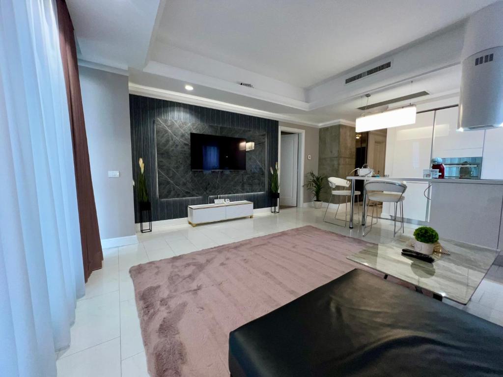 Il comprend un grand salon avec une télévision et une cuisine. dans l'établissement CLB Sea view Apartment, à Constanţa