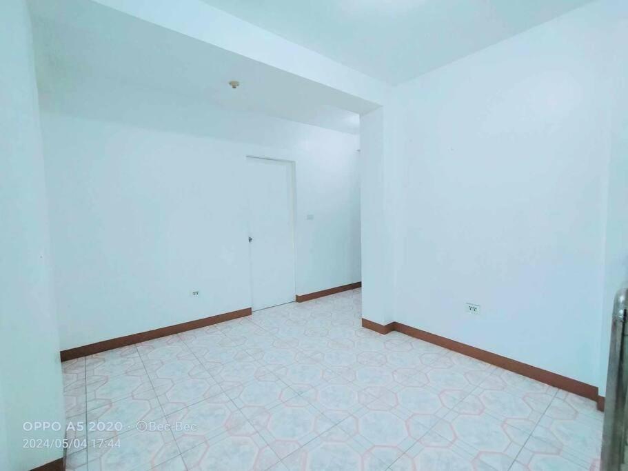 an empty room with white walls and a tile floor at White House Villa in Dumaguete