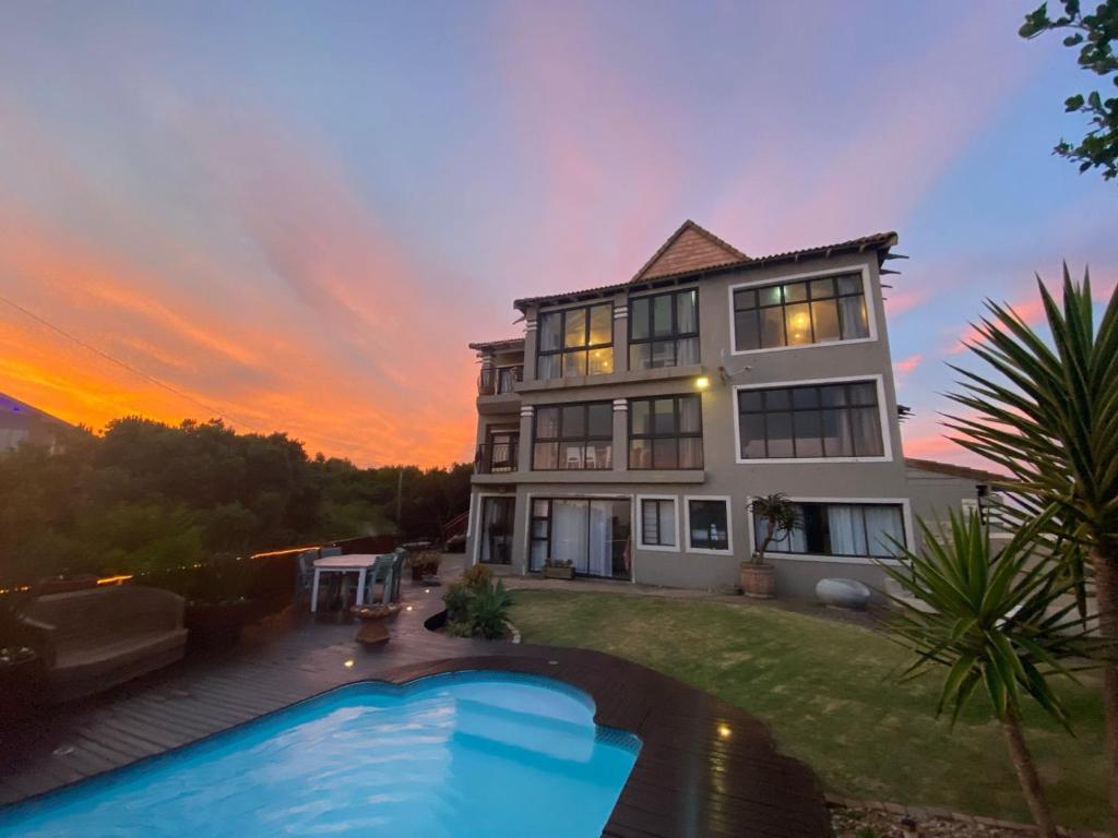 a house with a swimming pool in the yard at Sola Fide Self Catering Apartment in Jeffreys Bay