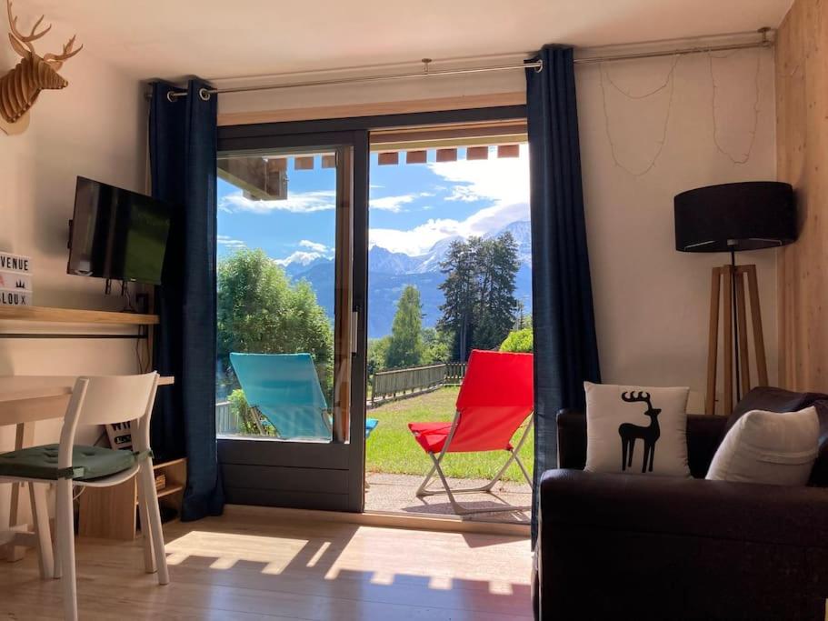 a living room with a sliding glass door with a view at La marmotte: Vue Mont Blanc, terrasse, parking in Combloux