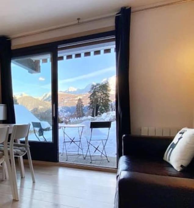 un salon avec un canapé et une porte coulissante en verre dans l'établissement La marmotte: Vue Mont Blanc, terrasse, parking, à Combloux