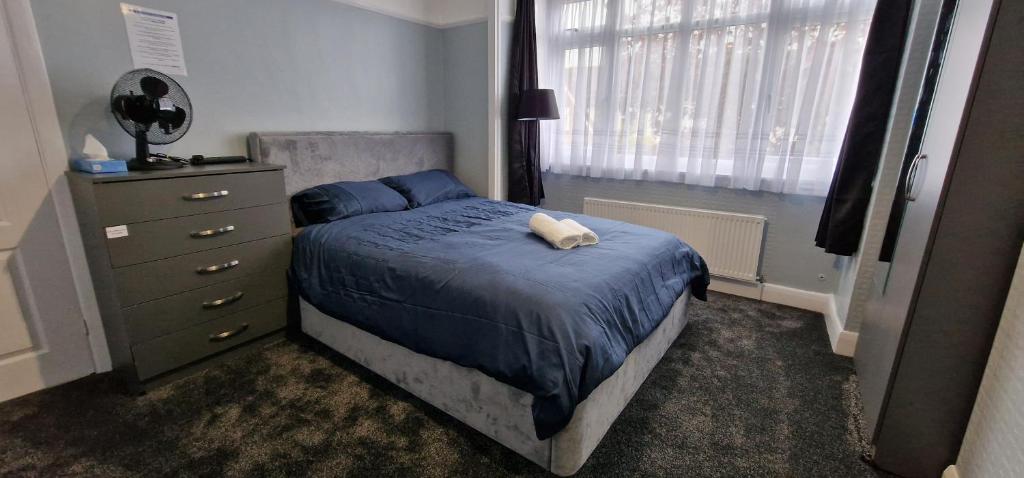 a bedroom with a bed and a dresser and a window at Rowan Crescent's Luxury Stay-In in Streatham Vale