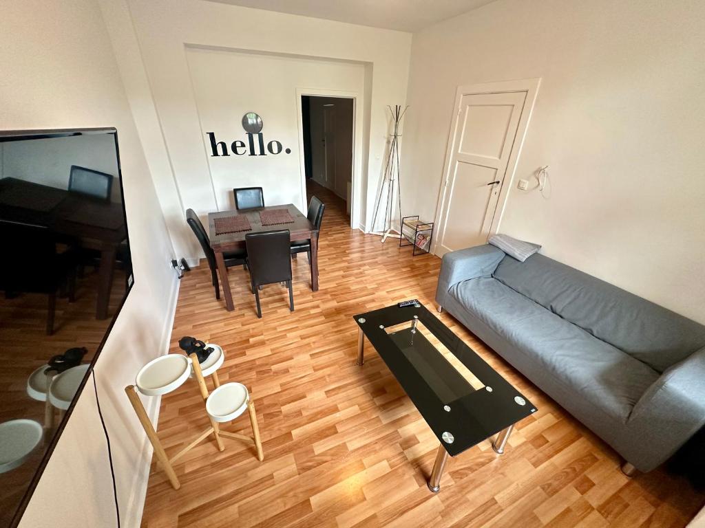 uma sala de estar com um sofá e uma mesa em Appartement rénové em Bruxelas