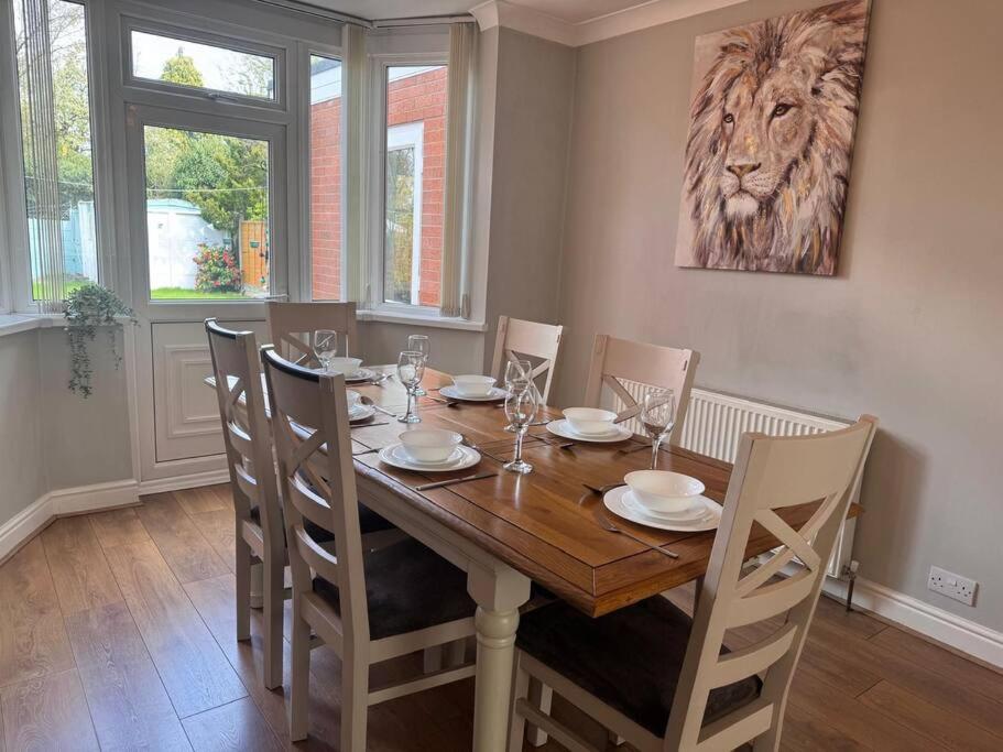 un comedor con una mesa con sillas y una pintura del león en Beautiful Home near Birmingham, en Smethwick
